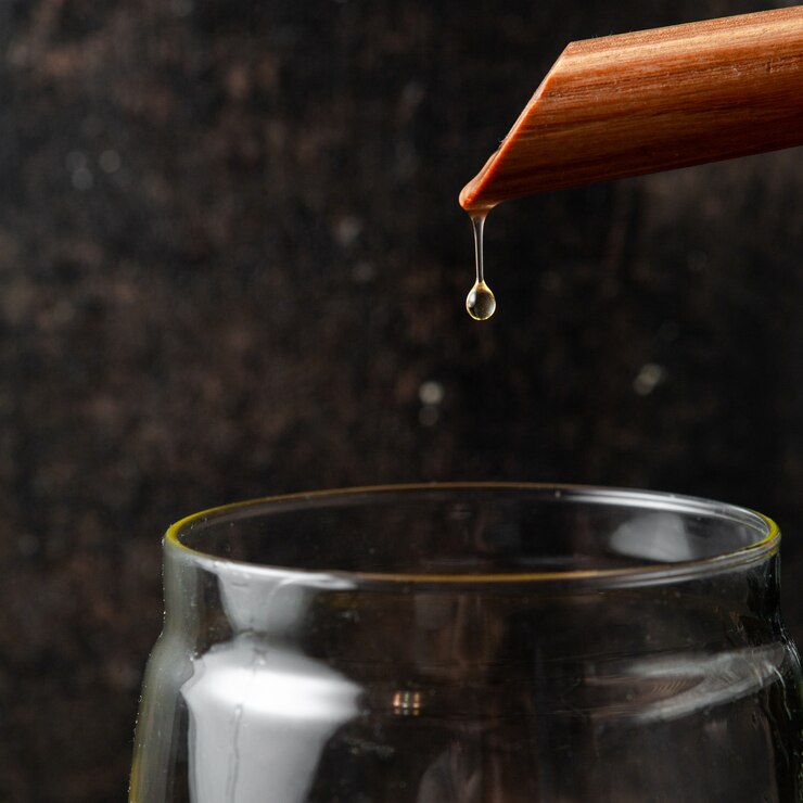 pouring-oil-into-glass-jar-close-up_176474-5502